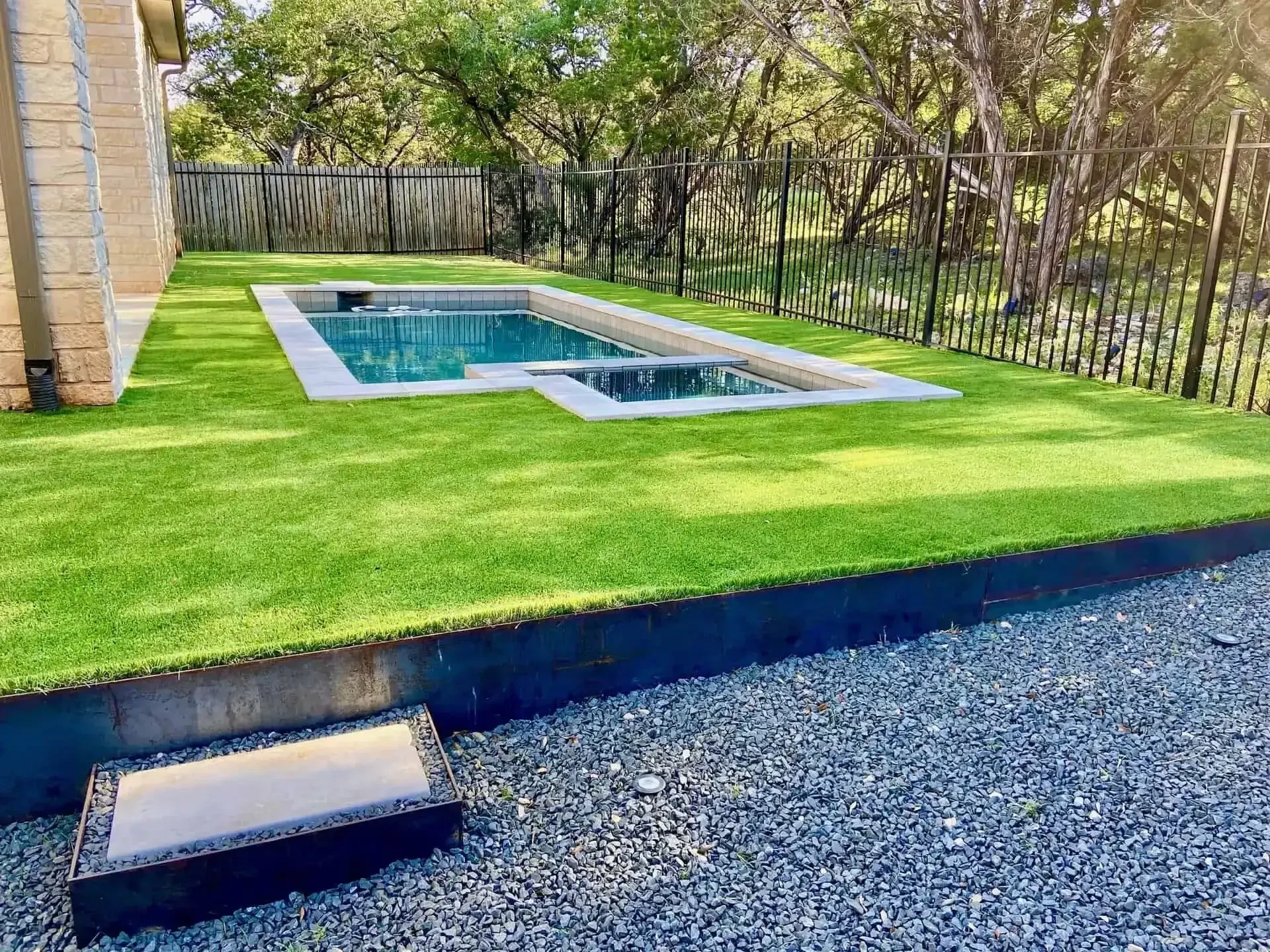 Natural sod lawn with steel edging and pool Austin TX