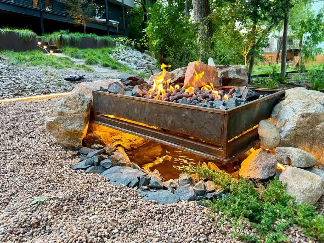 Custom welded steel fire pit with volcanic rock and boulders Austin TX