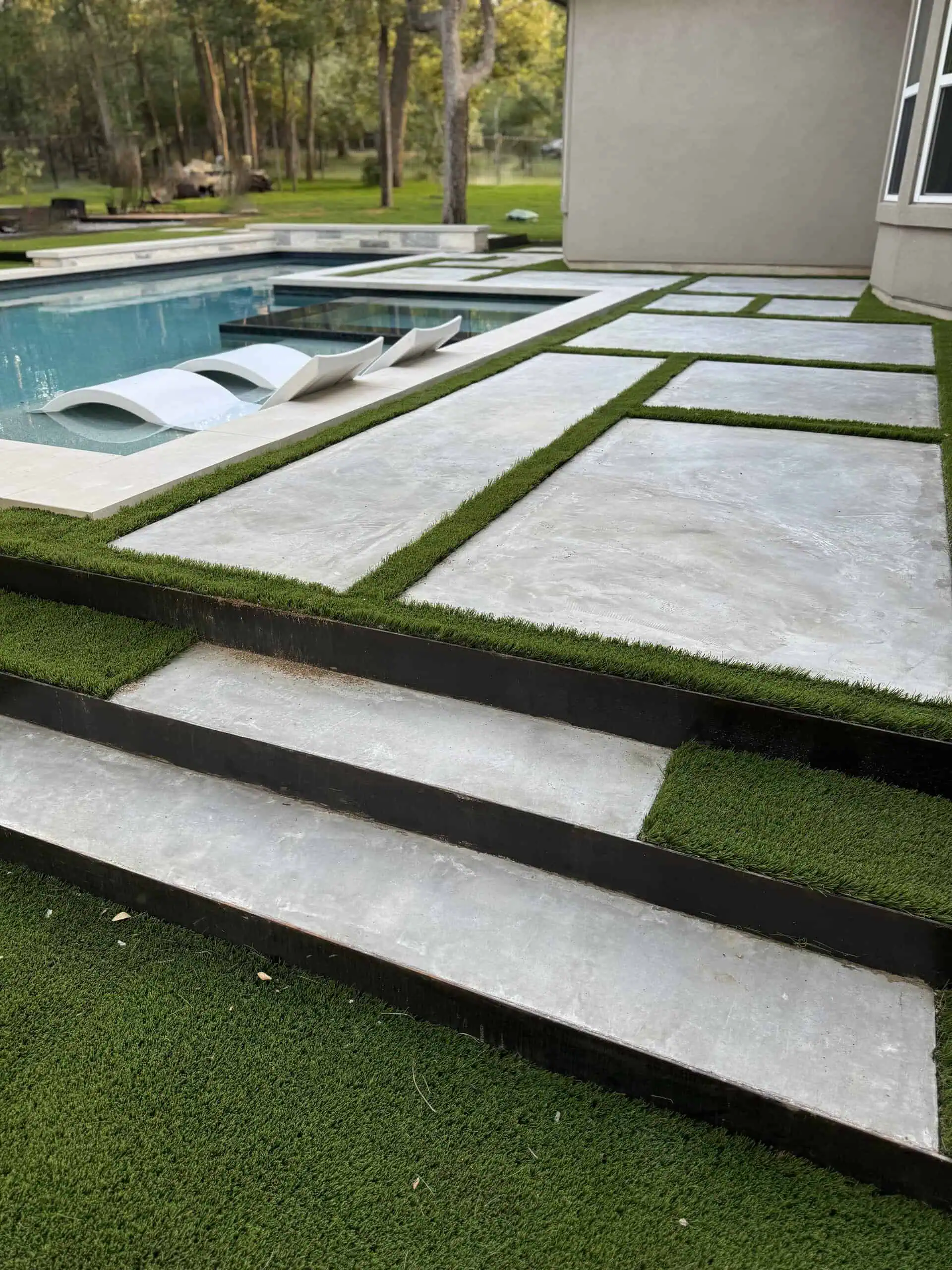 Large format pavers with synthetic turf joints and 1/4-inch steel terracing — Austin TX