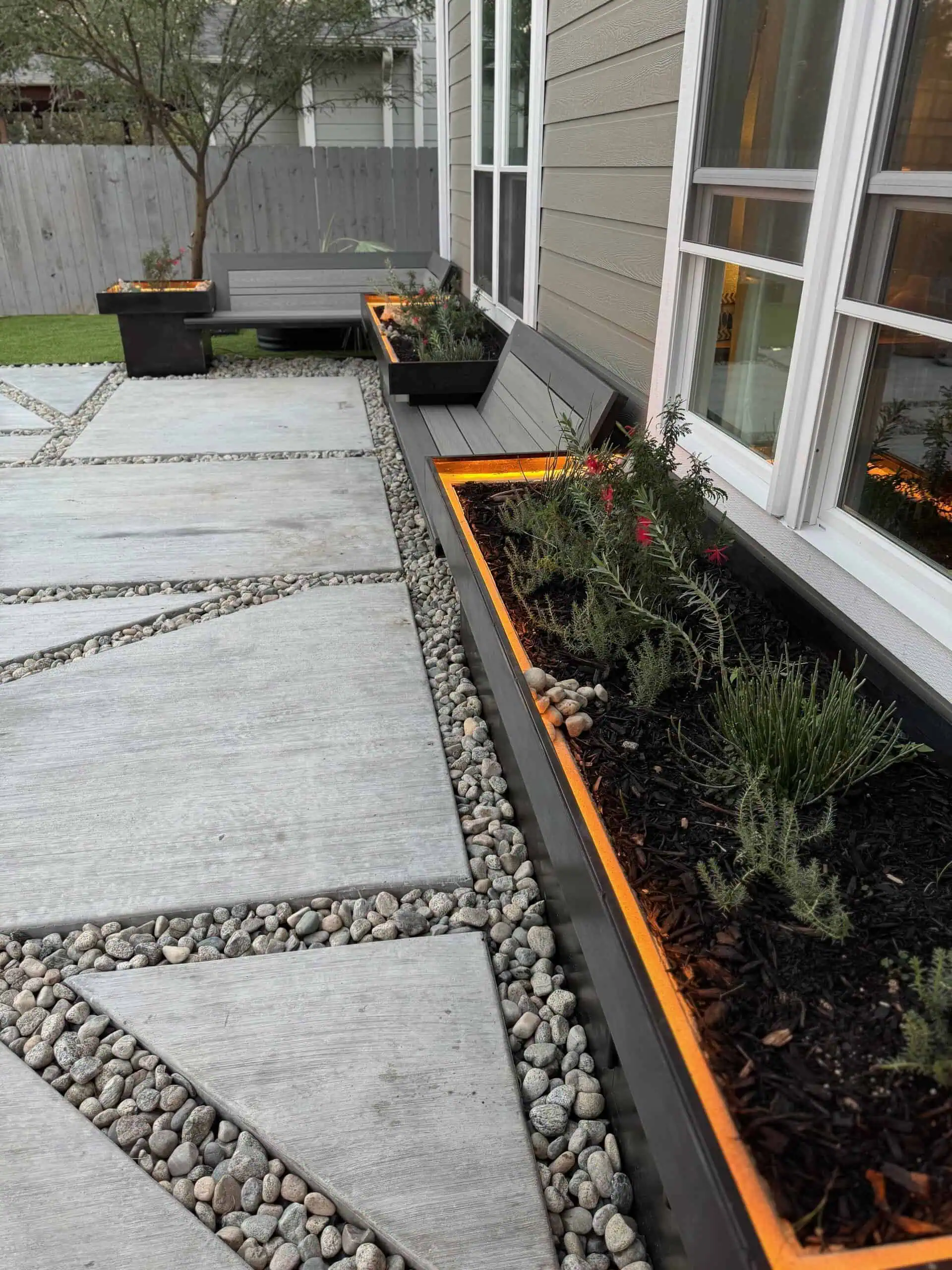 Geometric poured concrete pavers with limestone boulders + Ultra-Real synthetic turf — Circle C, Austin TX