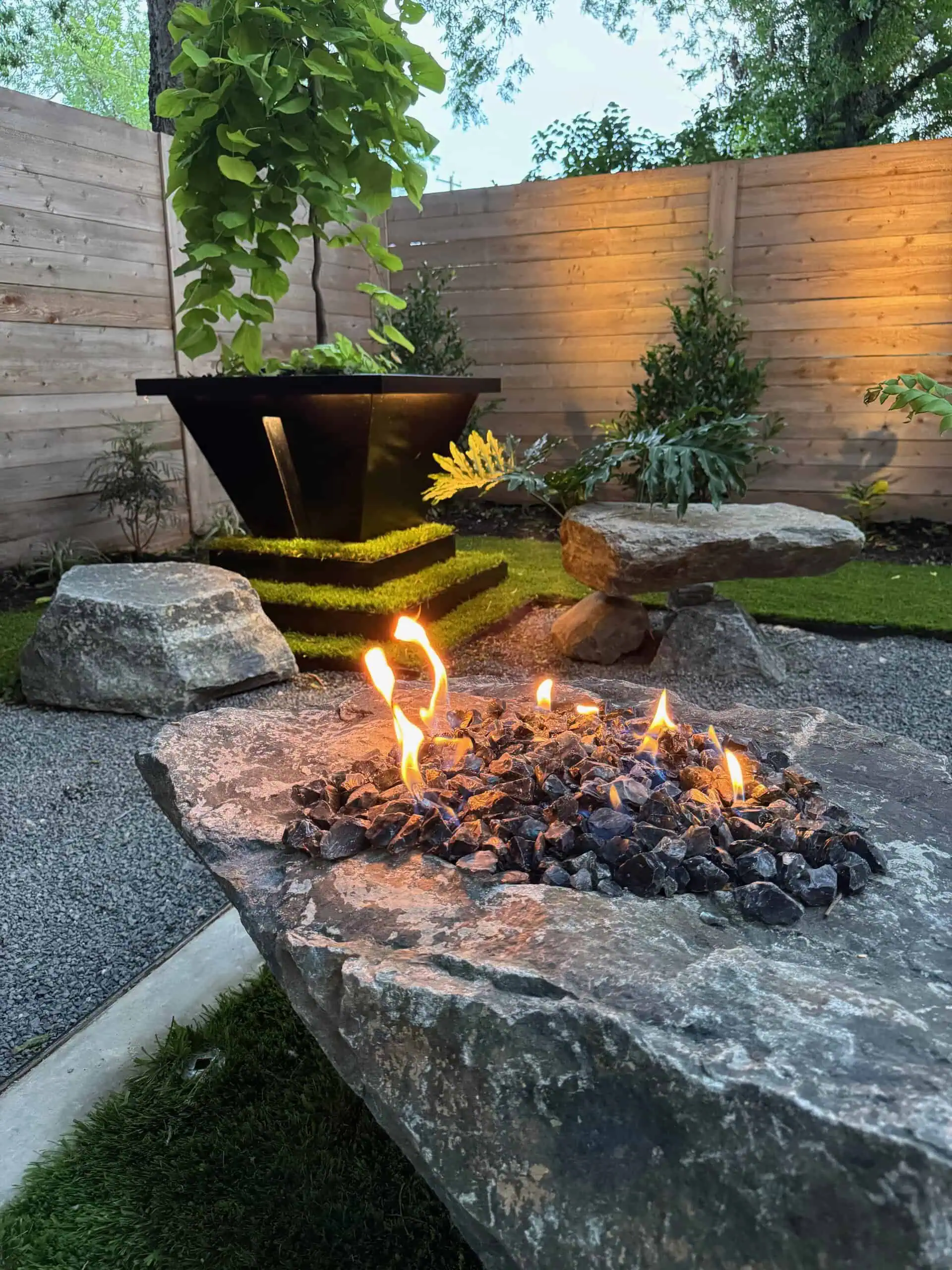 Boulder fire pit and bench in composition — Austin TX