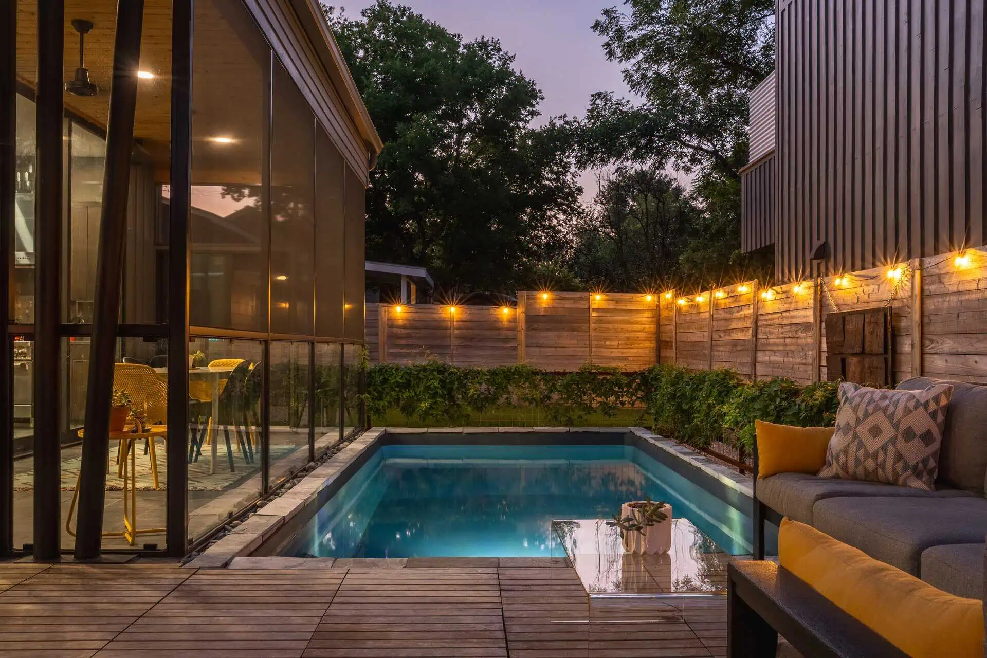 Pool, teak deck, and cedar fence at dusk — East Austin TX